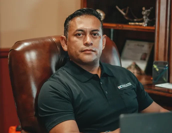 Omar Nolazco, president of North Carolina Water and Fire disaster recovery services company sitting at his desk